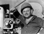 Photographer's Mate Marion L. Riley, with camera damaged during Battle of the Eastern Solomons.